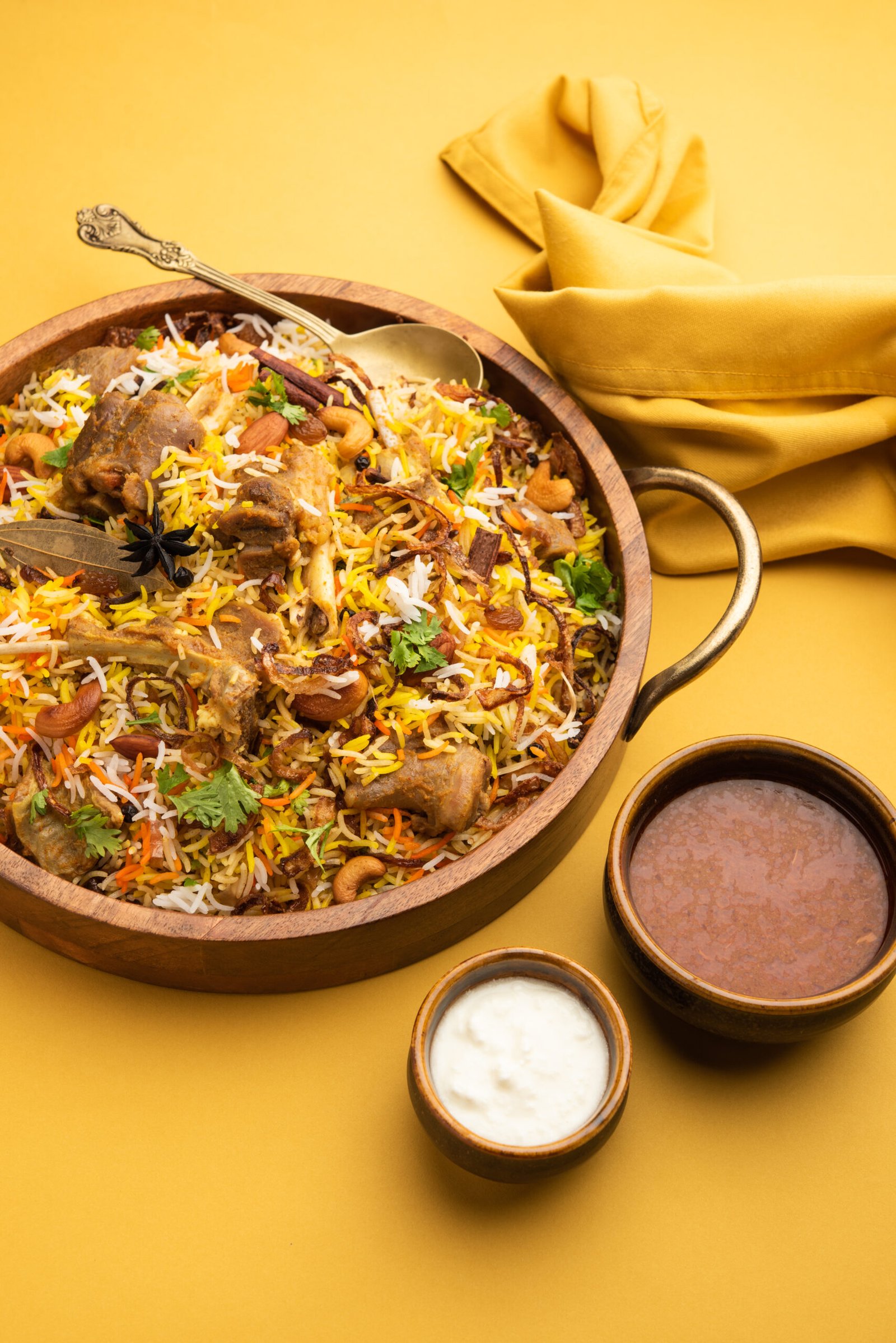 Indian Mutton biryani prepared in Basmati Rice served with Yogurt dip over moody background, Selective focus